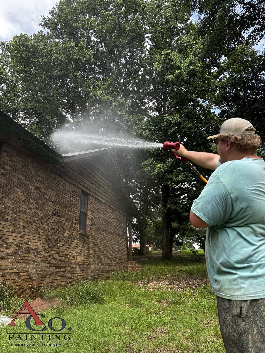 Soft washing a residential exterior at low pressure in Meridian, MS